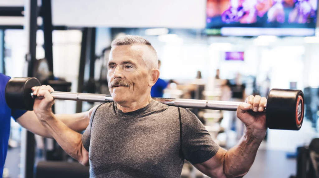 Senior lifting weights in gym setting.
